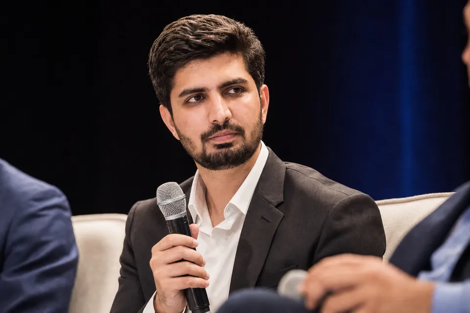 Hassaan Bukhari holding a microphone during a panel discussion