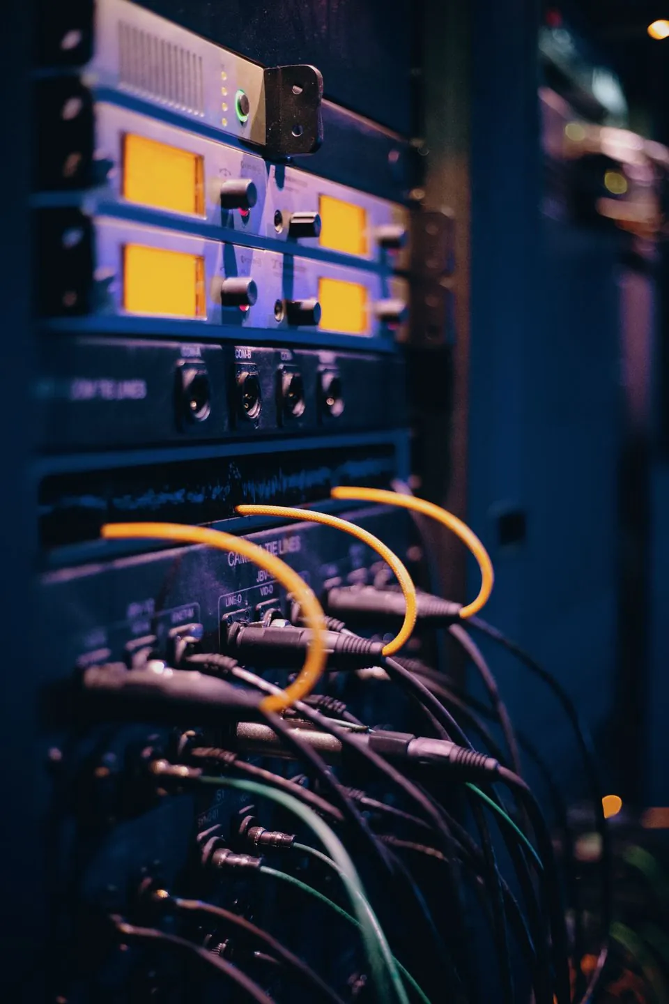 A rack of patch cables and connectors lit in blue, seen close up